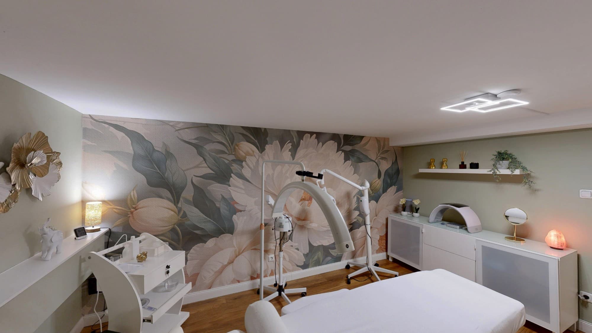 Private Beauty Room mit Behandlungsgeräten, weißem Sideboard und Blumentapete